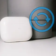Białe etui AirPods z niebieską ikoną resetowania.
